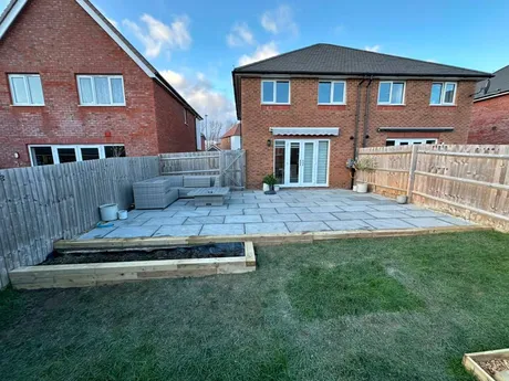 Patio lifted, relaid in Indian sandstone, sleeper flowerbed added.